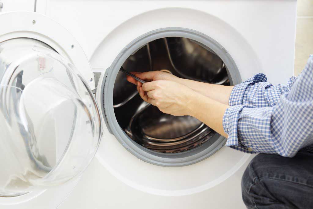 Technician repairing a washer/dryer